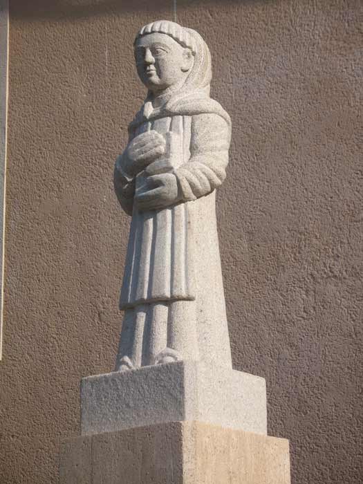 Ante la iglesia de Villamejil se ha ubicado una estatua de San Benito, copia de una obra románica local. guiarte.com