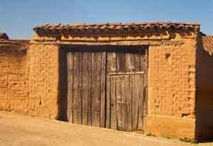 Villaveza conserva algunas casas en las que se aprecia la excelente labor en la arquitectura tradicional del barro, como en estas grandes puertas, en una pared de adobe. Imagen de guiarte.com