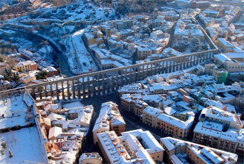 Una nevada tiñe de blanco el Acueducto romano de Segovia y los tejados de la ciudad. 