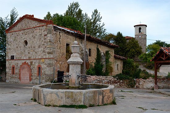 La bella fuente de piedra octogonal, con la ermita y, al fondo, la iglesia de Villambistia. Imagen de José Holguera (www.grabadoyestampa.com) para Guiarte.com