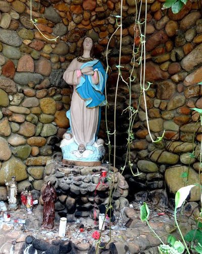 Imagen de la virgen, en una sencilla gruta artificial, ante el santuario de Lagoa da Conceição. Imagen Guiarte.com.
