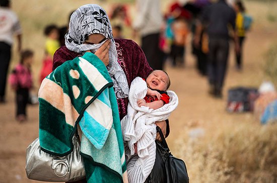 Una joven madre cruza la frontera de Siria y se convierte en refugiada. Lleva con ella a Hamid, su hijo de apenas un mes. ACNUR/S. Rich.