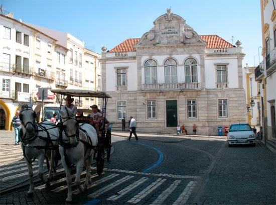 Carruaje de caballos, ante el banco de Portugal, en la plaza Giraldo de Évora. Imagen de Tomás Alvarez/Guiarte.com