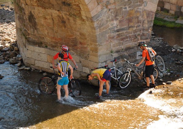 Peregrinos refrescándose en las aguas del río en Molinaseca (León). Imagen de Guiarte.com