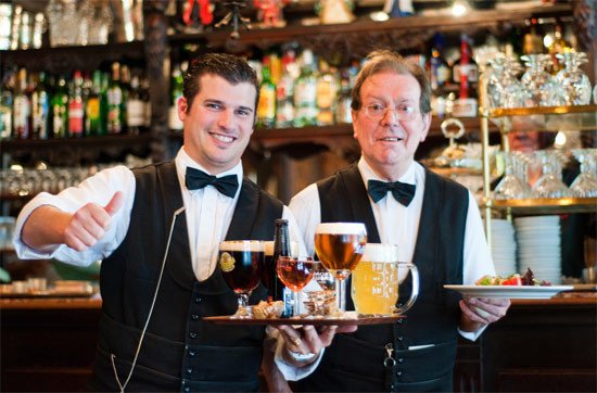 Dos camareros sirven cerveza belga en un bar de Flandes.