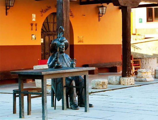 Un peregrino de bronce espera sentado ante un mesón de la población de Villasirga. Imagen de Guiarte.com