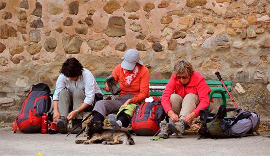 Peregrinos atendiendo sus pies, en la provincia de Burgos.  Imagen de José Holguera (www.grabadoyestampa.com) para Guiarte.com.