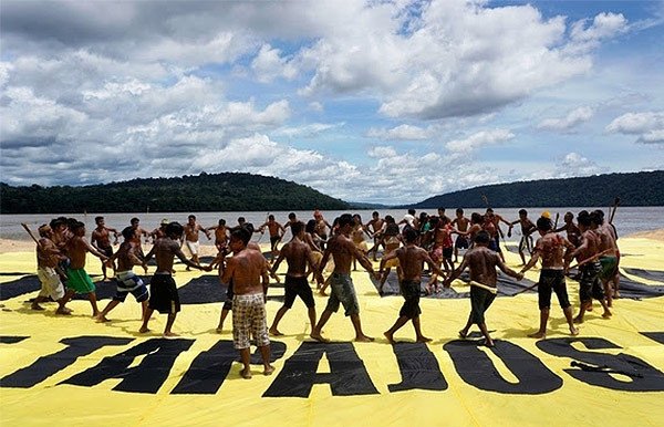 Activistas de Greenpeace Brasil junto a miembros de la tribu Mundurukú expresan su rechazo a este proyecto con pancartas. Foto Greenpeace.