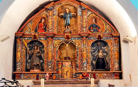 El colorista altar de la iglesia de Hospital de la Condesa, con un niño Jesús en la Cruz. Imagen de José Holguera (www.grabadoyestampa.com) para Guiarte.com.