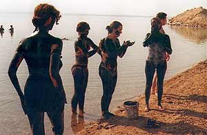 Turistas embadurnándose de lodo, en la orilla del Mar Muerto. Imagen de guiarte.com. Copyright
