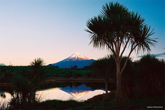 El  monte Taranaki, el volcán típico de Nueva Zelanda, se refleja en las aguas del Whanganui. Es un paisaje de enorme valor cultural para los maoríes. Imagen de James Heremaia / Tourism New Zealand