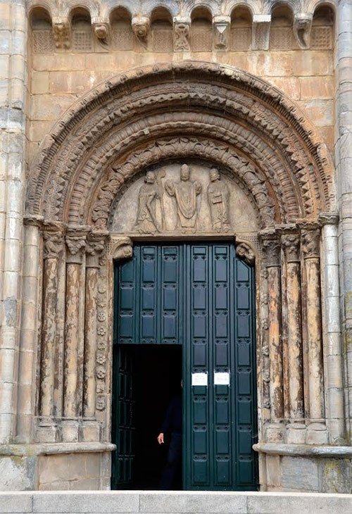 Otra de las puertas del templo mayor de Puertomarín, con un obispo rodeado de dos acólitos en el tímpano. Imagen de José Holguera para Guiarte.com