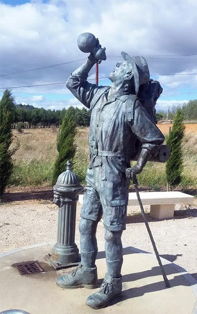 Peregrino de bronce sacia su sed en San Justo de la Vega. La estatua de obra de Sendo. Imagen de Guiarte.com