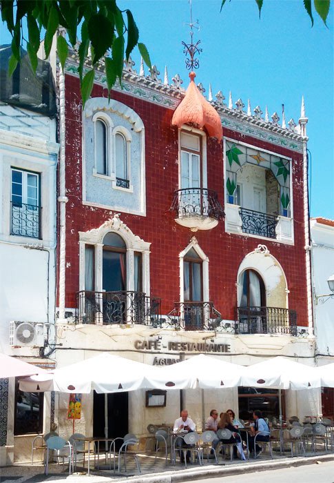 Entre la blancura de la ciudad, el café Águilas de oro, de estilo modernista y tonos rojizos. Imagen de Guiarte.com