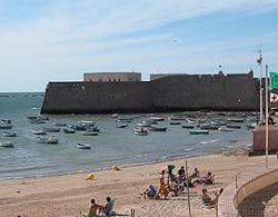 Al lado del mar, la silueta del fortín evoca el carácter estratégico de la ciudad. guiarte.com. Copyright