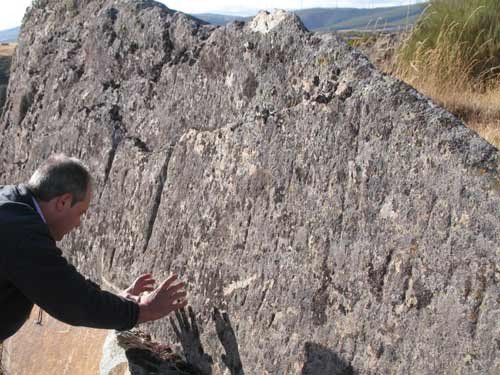 Juan Carlos Campos examina otra roca con inisiones, en el entorno de La Chana(León)
