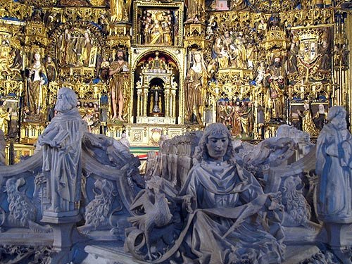 El colorido del retablo destaca tras los tonos de alabastro del sepulcro real. Imagen de Guiarte.com