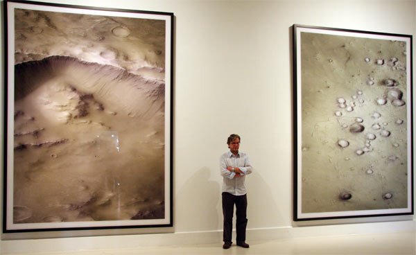 El artista Tomas Ruff junto a dos de las obras expuestas en el CAC.