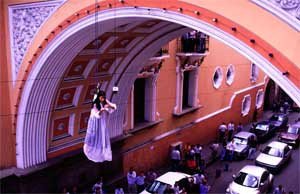 Regina Galindo. Lo voy a gritar al viento, 1999. Colgada del arco del Edificio de Correos de la ciudad de Guatemala y leyendo poemas al aire. (II Festival del Centro Histórico. Arco de Correos)