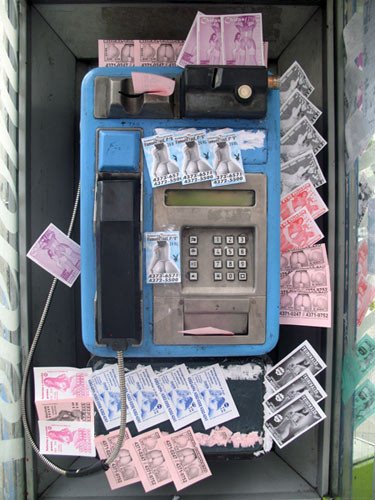 Cabina telefónica ocupada por los anuncios de prostitución, en la avenida de Callao. Imagen de Beatriz Álvarez Sánchez