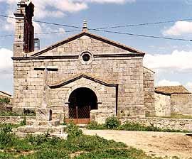 El crucero y la sólida iglesia iglesia de Valverde de Valdelacasa. Foto guiarte